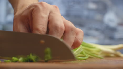 To-cut-green-onions.-The-cuts-green-onions-on-a-wooden-board.-Healthy-food